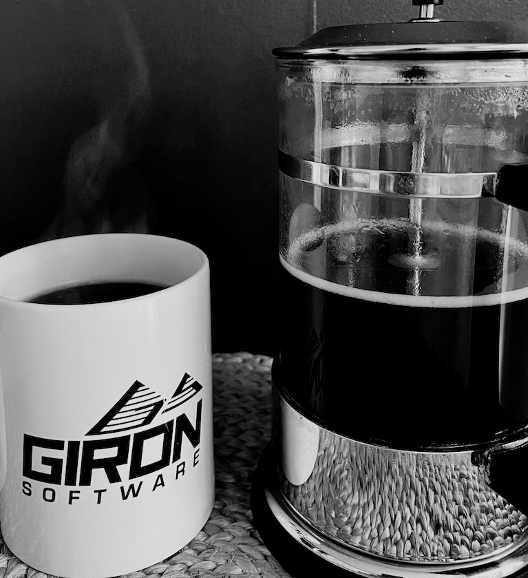 A coffee mug with Giron Softwarse logo nad a coffe machine